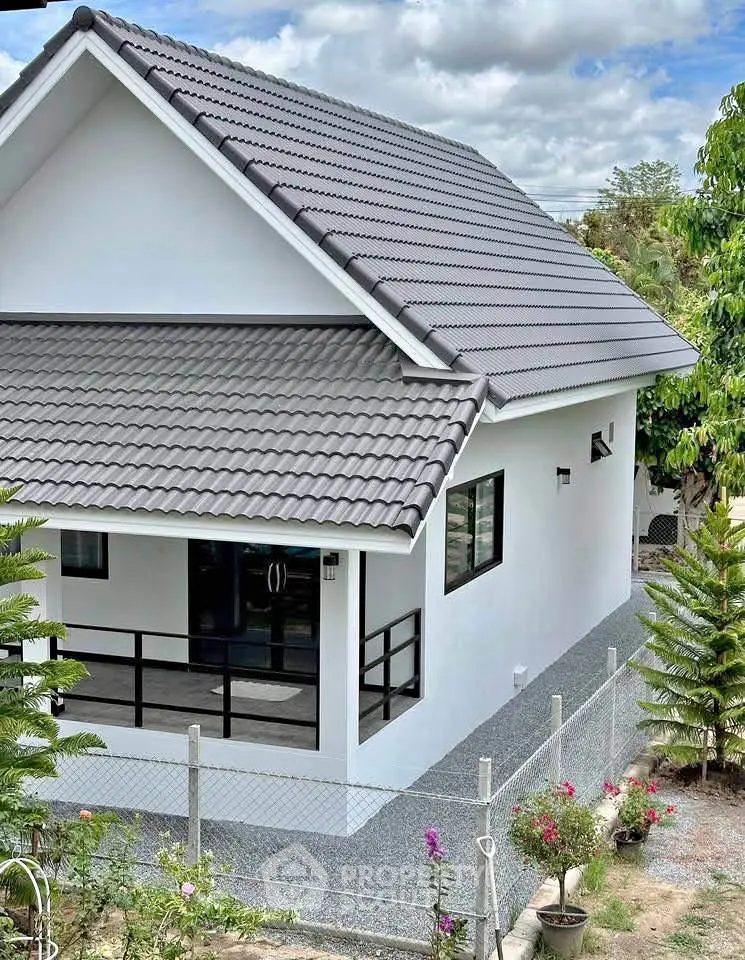 Charming modern house with sleek roof design and spacious outdoor area, perfect for family living.