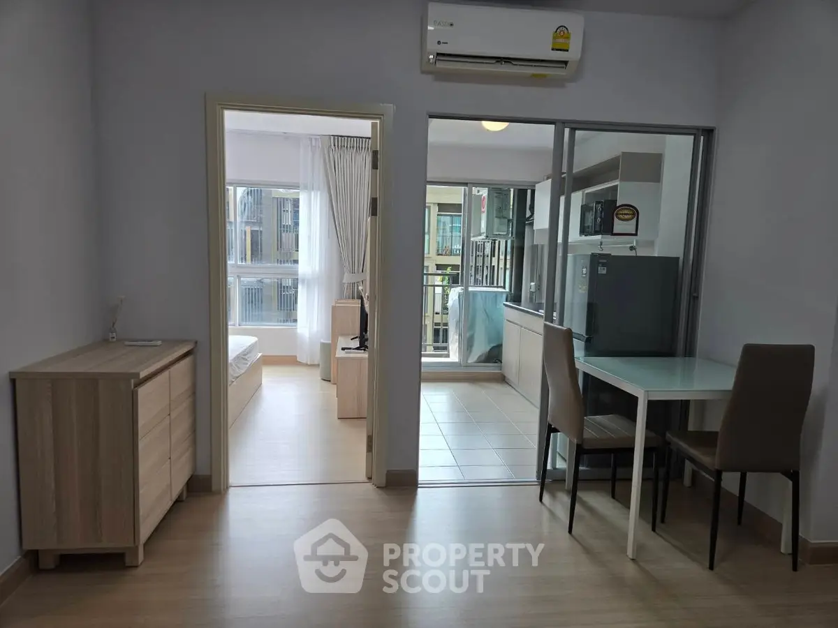 Modern apartment interior with open layout, featuring a dining area, bedroom, and balcony with ample natural light.