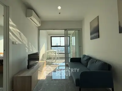 Modern living room with city view, sleek furniture, and abundant natural light.