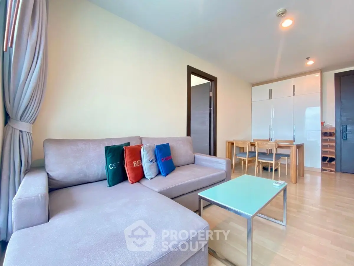 Modern living room with cozy sofa and dining area in open layout apartment.