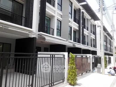 Elegant townhouses with modern black and white facades, offering a secure gated community living experience in a prime location.