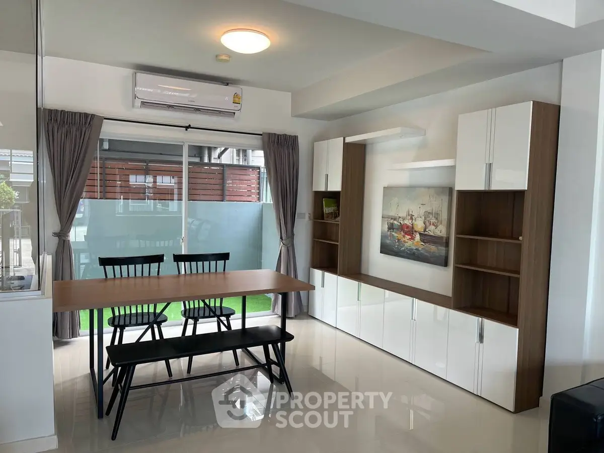 Modern dining area with sleek furniture and large window for natural light