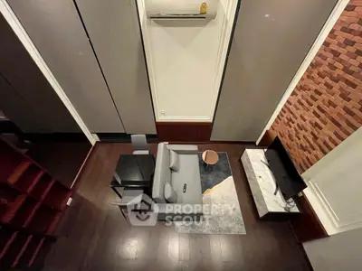 Modern living room with high ceiling, stylish furniture, and wall-mounted TV in a cozy apartment.