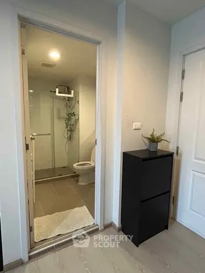 Modern bathroom with glass shower and sleek black cabinet