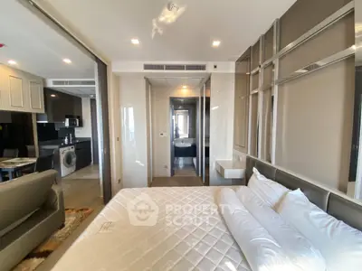 Modern bedroom with luxurious decor and open layout to kitchen and living area.