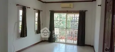Spacious living room with large windows and air conditioning unit.