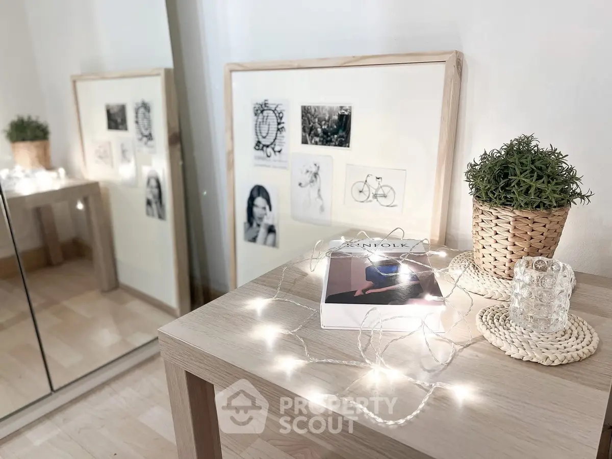 Chic interior decor with framed art, potted plant, and stylish magazine on wooden table.