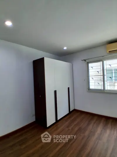 Spacious bedroom with modern wardrobe and wooden flooring