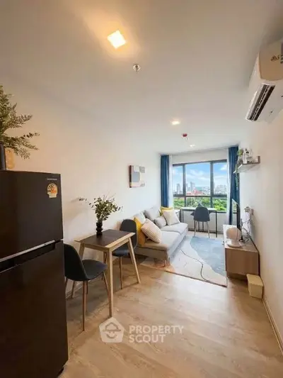 Modern living room with stylish decor and city view, featuring cozy seating and natural light.