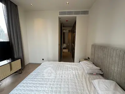 Modern bedroom with stylish decor and city view, featuring a comfortable bed and sleek furniture.