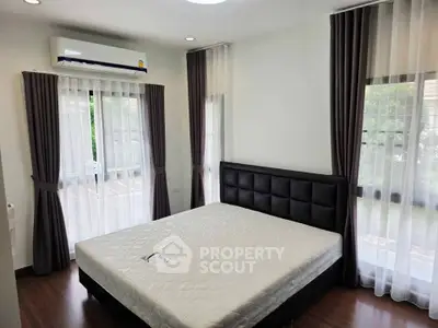 Spacious bedroom with large windows and modern air conditioning unit, featuring elegant curtains and a comfortable bed.