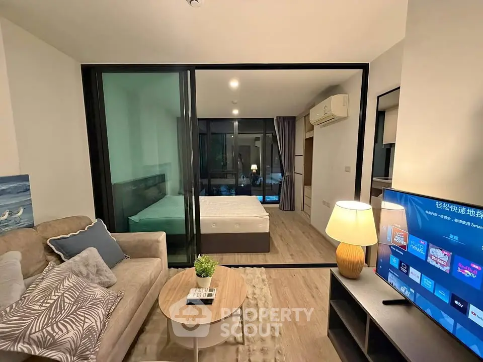 Modern studio apartment with glass partition, cozy living area, and stylish decor