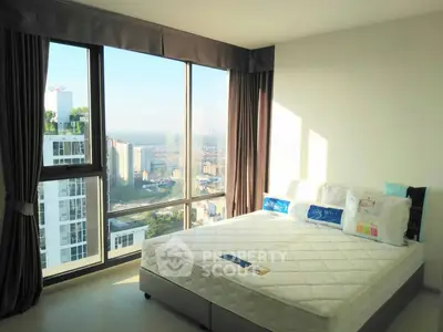 Bright bedroom with large windows offering stunning city views in modern apartment.