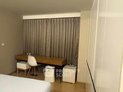Modern bedroom with sleek desk and chair, featuring minimalist design and neutral tones.