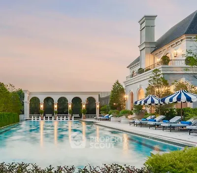 Luxurious estate with grand pool and elegant architecture at sunset.