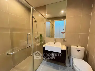 Modern bathroom with glass shower and sleek fixtures in a contemporary home.
