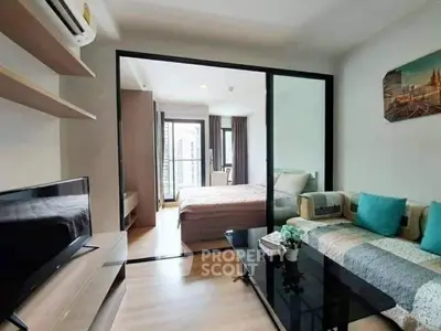 Modern apartment with open living room and bedroom, featuring stylish decor and natural light.