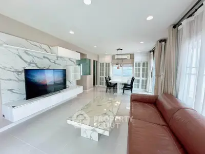 Spacious modern living room with marble accents and large windows for natural light.
