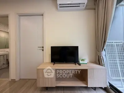 Modern living room with sleek TV stand and air conditioning, adjacent to a bathroom and balcony.