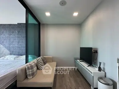 Modern living room with sleek design and adjacent bedroom view