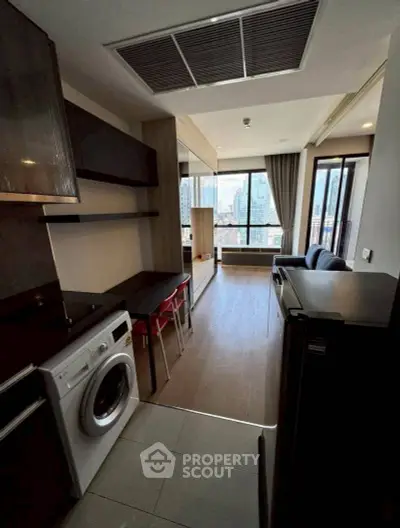 Modern apartment with open layout, featuring a washing machine and city view.