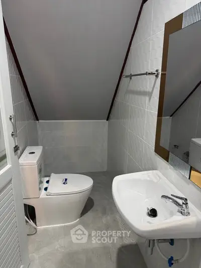Modern attic bathroom with sleek fixtures and sloped ceiling design