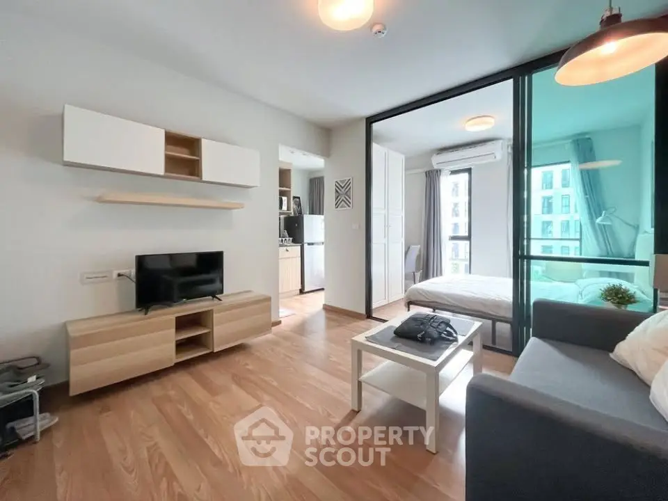 Modern open-plan living room with wooden flooring and stylish furniture in a bright apartment.