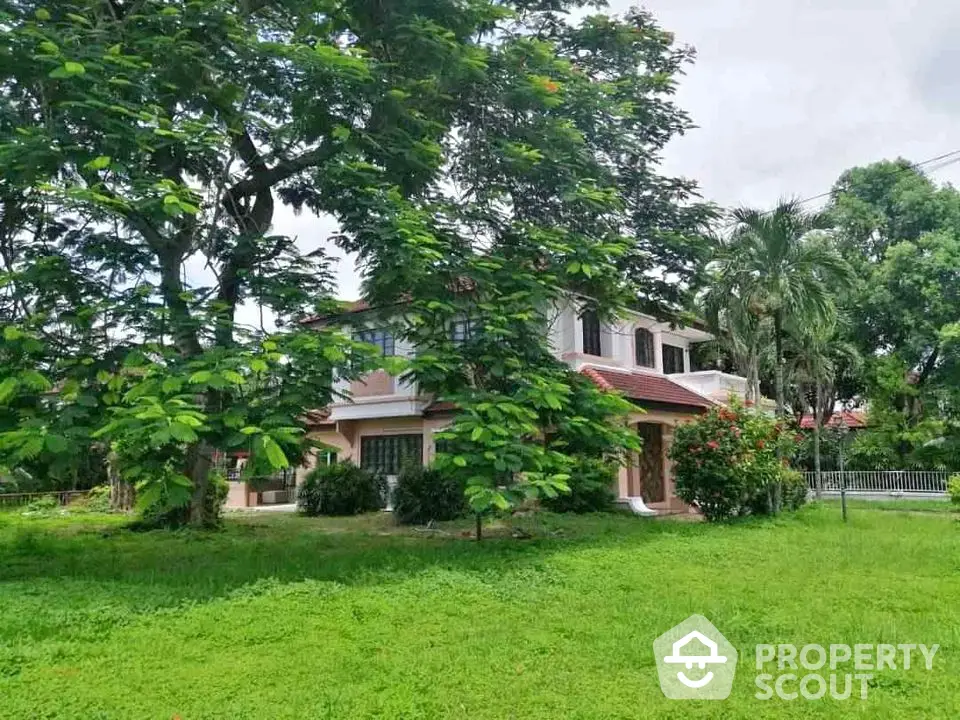 Charming two-story house with lush green garden and mature trees