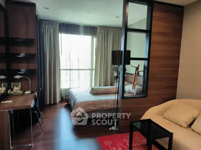 Modern bedroom with stylish decor and natural light, featuring a cozy workspace and elegant furnishings.