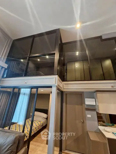Modern loft-style apartment with high ceilings and glass partitions