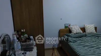Cozy bedroom with wooden bed and wardrobe, featuring stylish decor and comfortable bedding.