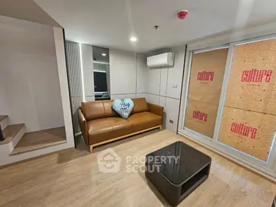 Modern living room with stylish brown sofa and sleek coffee table, featuring a cozy ambiance and contemporary design.
