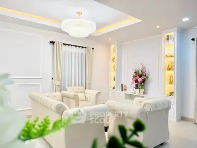 Elegant living room with plush white sofas and a stunning chandelier