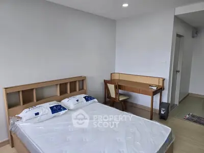 Modern bedroom with wooden furniture and natural light, perfect for a cozy living space.