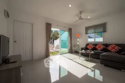 Bright living room with modern decor and sliding glass doors leading to a sunny patio.