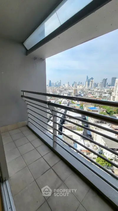 Stunning city view from a high-rise balcony with modern railing and tiled floor.