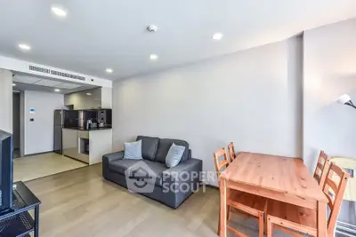 Modern living room with cozy sofa and dining area in open layout apartment.