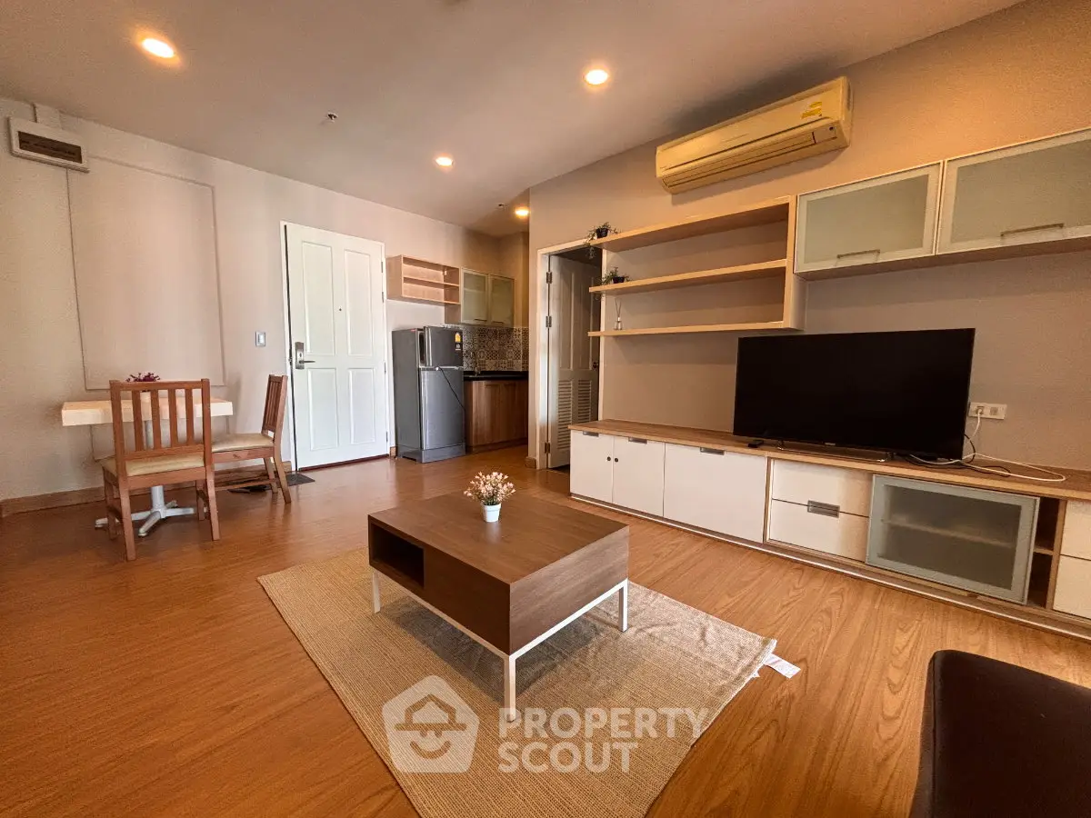 Spacious living room with modern furniture and open kitchen layout in a stylish apartment.