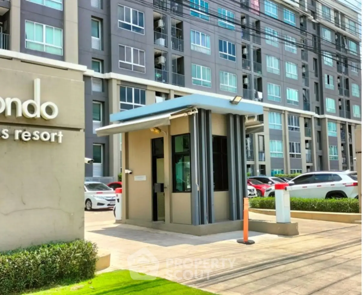 Modern condominium entrance with security booth and parking area