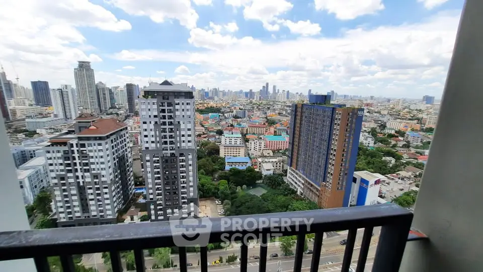 Stunning cityscape view from a high-rise balcony overlooking urban skyline and lush greenery.