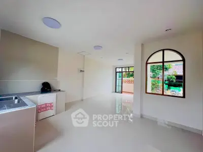 Spacious open-plan living area with large windows and garden view