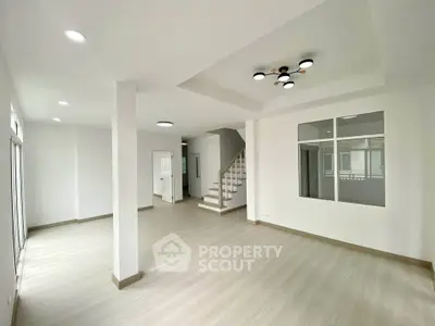 Spacious modern living room with sleek flooring and stylish lighting in a contemporary home.