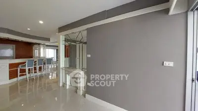 Spacious modern living room with sleek design and bar seating area.