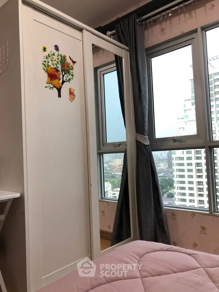 Cozy bedroom with large windows offering city views and stylish wardrobe.
