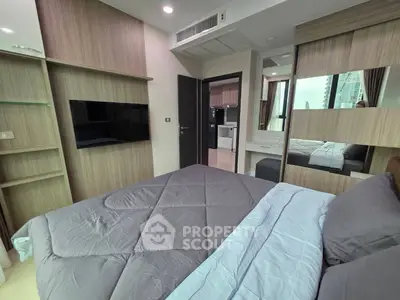 Modern bedroom with sleek design and city view, featuring a wall-mounted TV and stylish bedding.