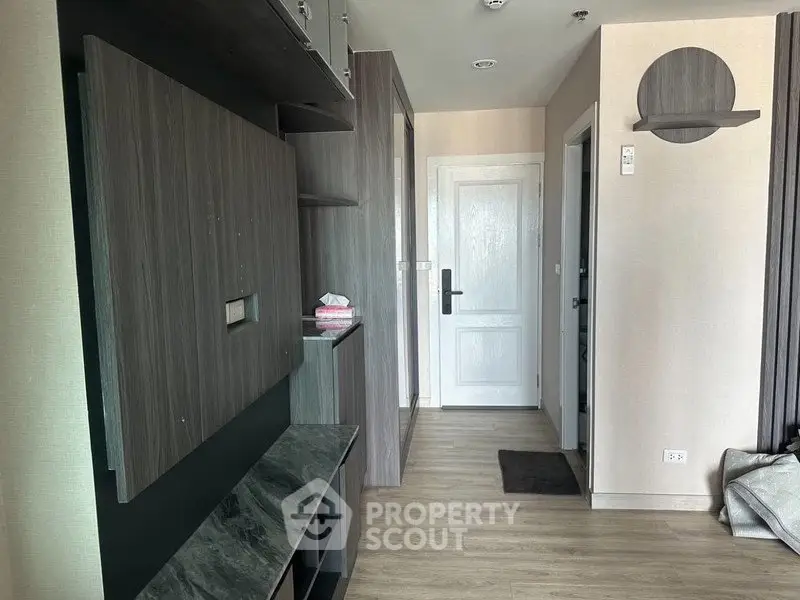 Modern apartment hallway with sleek wooden finishes and white door