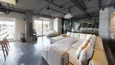 Spacious modern living room with large sectional sofa and balcony view