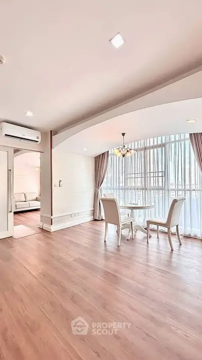 Spacious living room with elegant dining area and large windows for natural light.