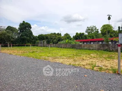 Spacious vacant land plot with lush greenery, ideal for development in a serene neighborhood.