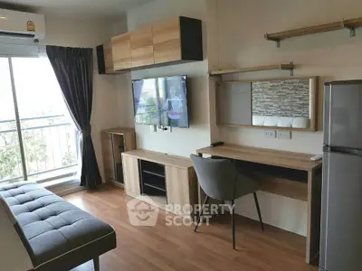 Modern living room with balcony, stylish furniture, and wall-mounted TV in a cozy apartment.
